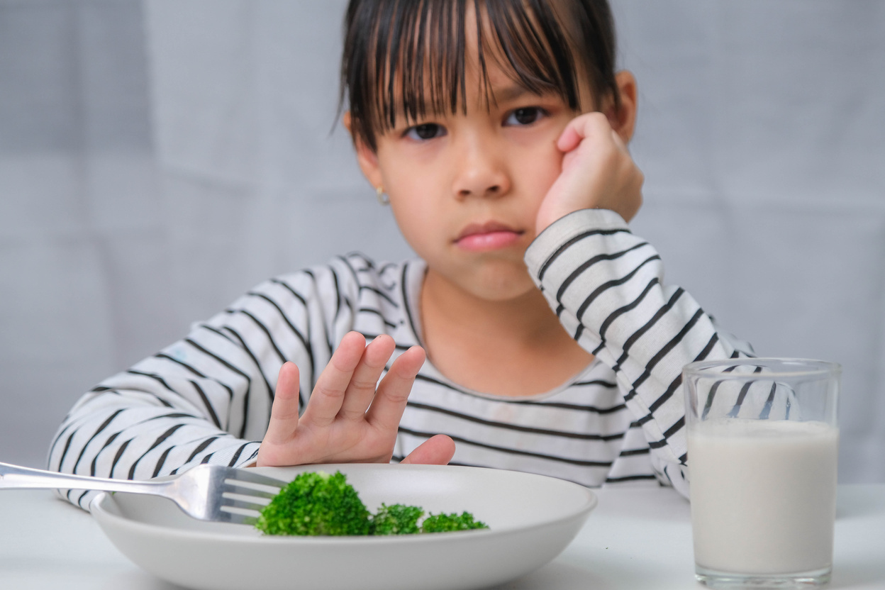 Children Don't like to Eat Vegetables. Cute Asian Girl Refusing